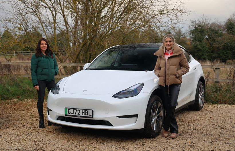 Ginny Buckley and Nicki Shields with a white Tesla Model Y